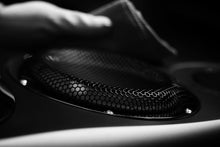 Close-up of a Estelon Forza Reference Speaker with a hand holding a cloth.