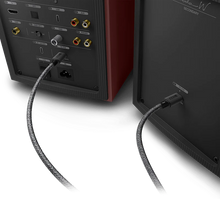 Two audio KEF Coda W Powered Speakers with cables connected on a white background