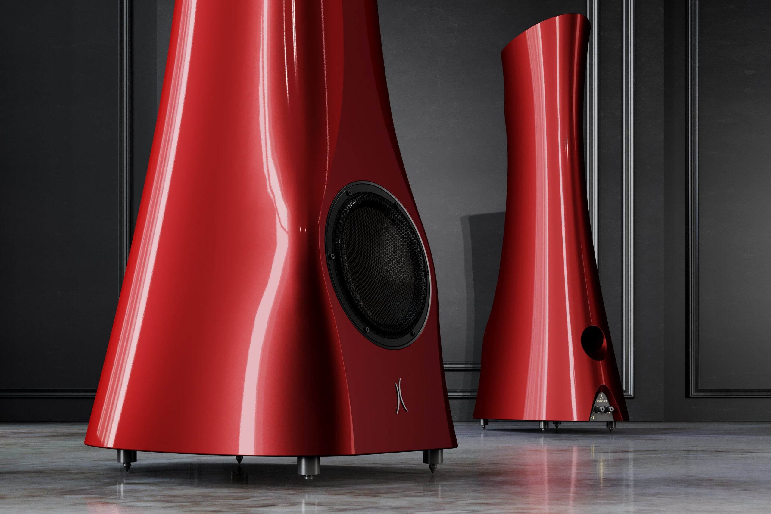 A closeup on a pair of Red Rocket Liquid Gloss Estelon XB Diamond MK II floor-standing speakers with a diamond tweeter and a mid-woofer. in an upscale living room.