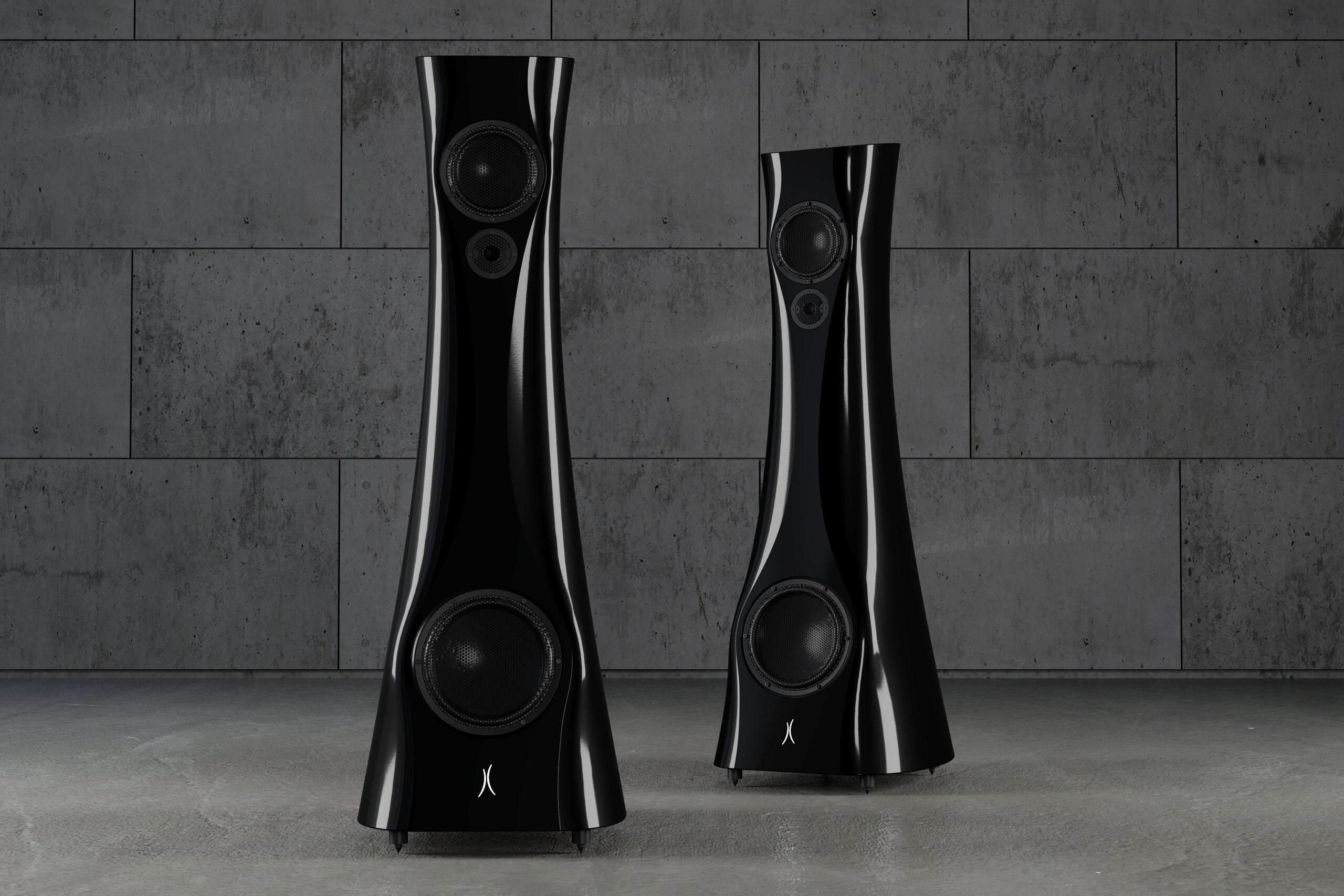 A pair of Black Lava Liquid Gloss Estelon XB MK II reference speakers with a curved-sculptural design, standing in an industrial environment.