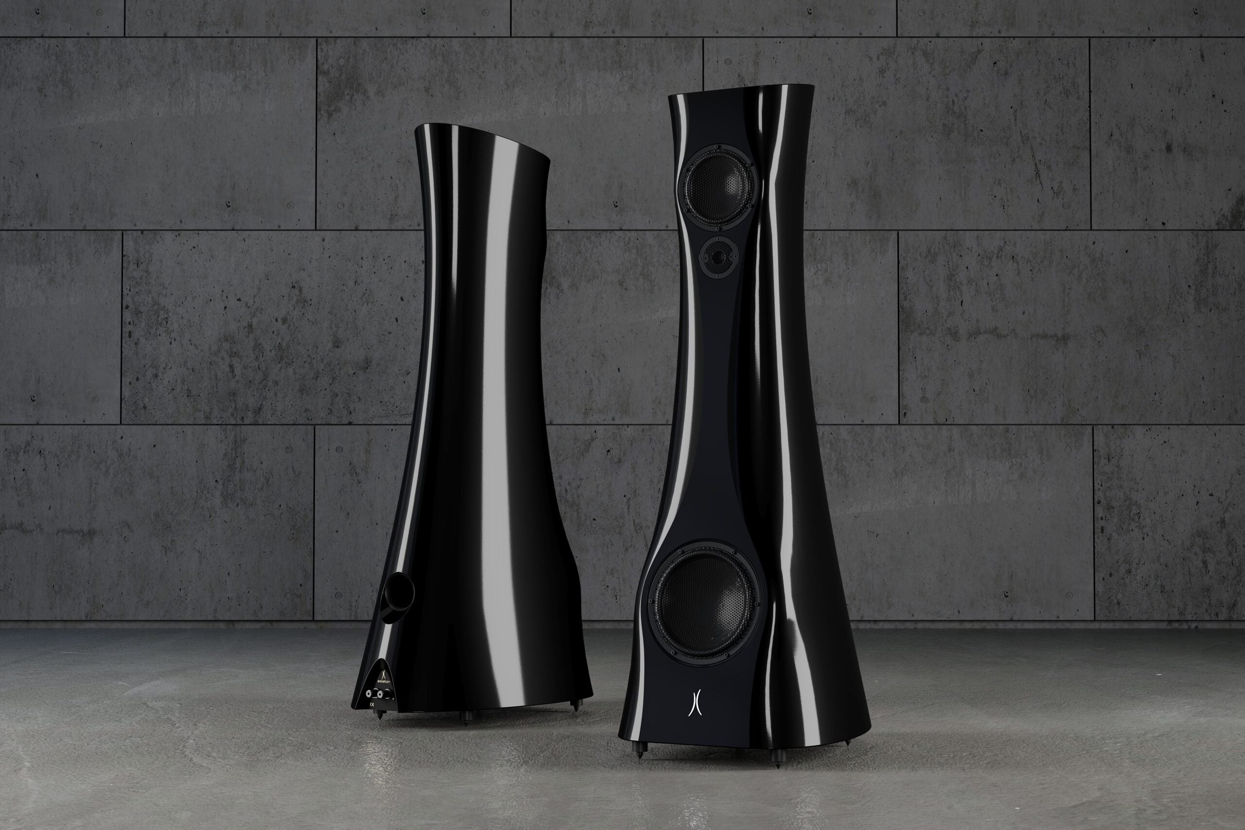 A pair of Black Lava Liquid Gloss Estelon XB MK II reference speakers with a curved-sculptural design, standing in an industrial environment.