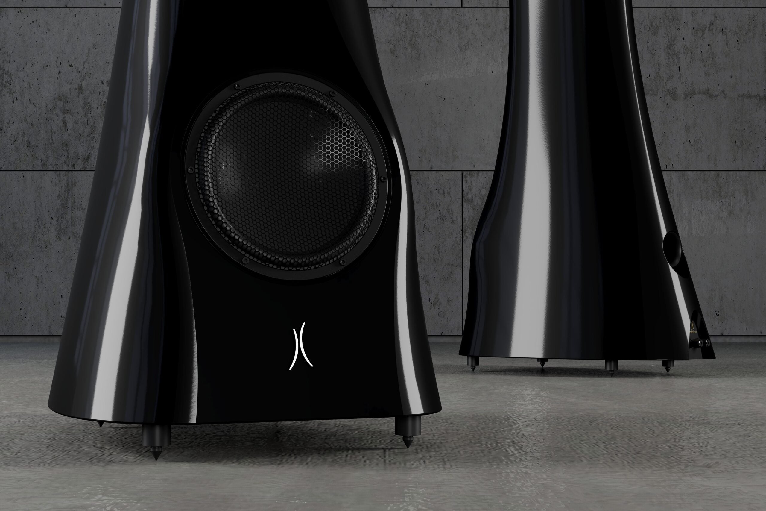 A closeup of a pair of Black Lava Liquid Gloss Estelon XB MK II reference speakers with a curved-sculptural design, standing in an industrial environment.