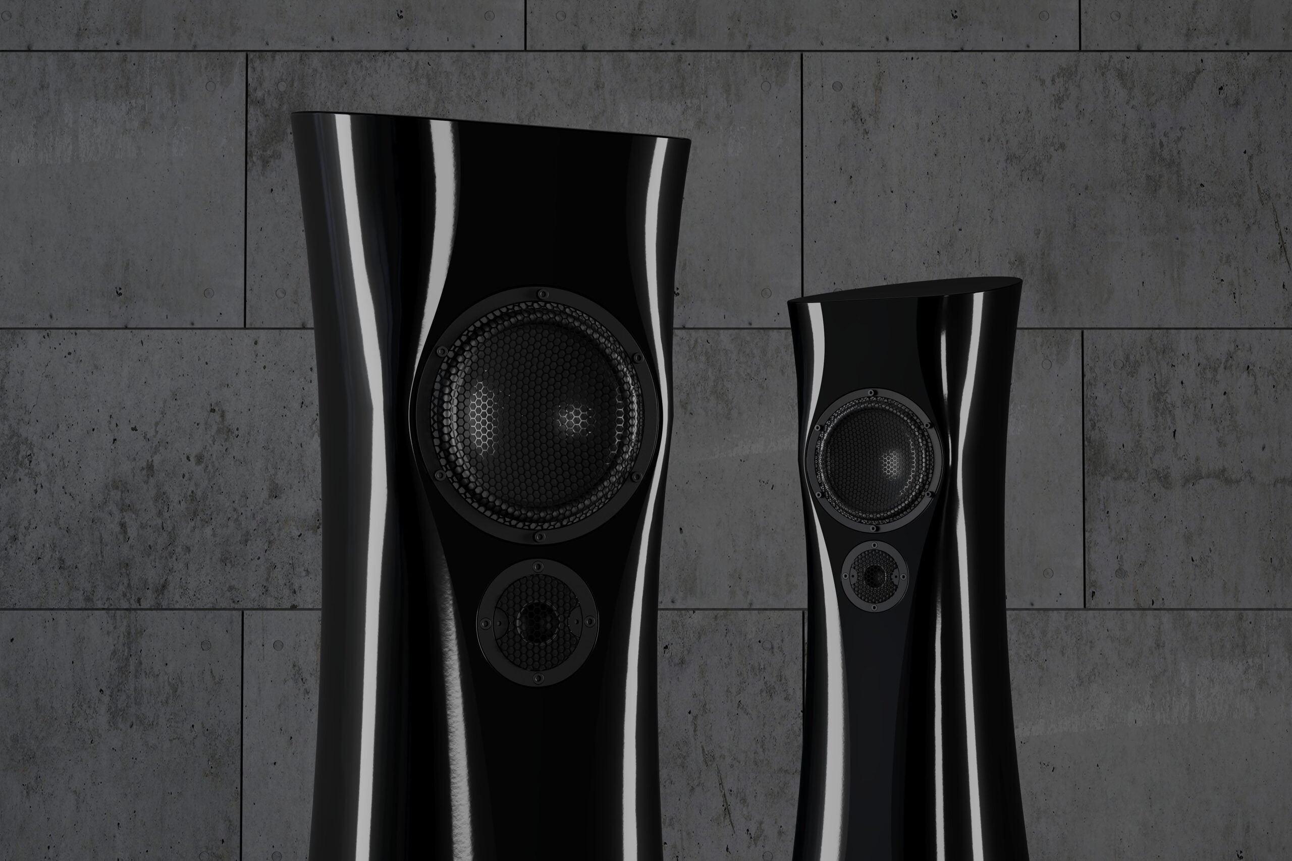 A closeup of a pair of Black Lava Liquid Gloss Estelon XB MK II reference speakers with a curved-sculptural design, standing in an industrial environment.