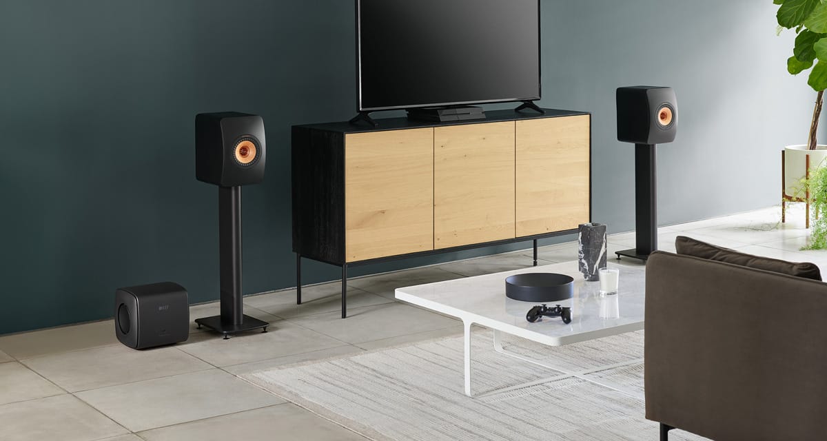 Modern living room with a television, wooden cabinet, and speakers and a black KEF KC62 Subwoofer.