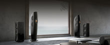 Modern home theater speakers and black KEF KC92 Dual 9” Subwoofers in a room with a large window.