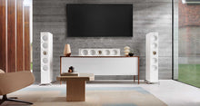 Modern living room with white floor-standing KEF Reference 4 Meta
 speakers, a television, and decorative items.