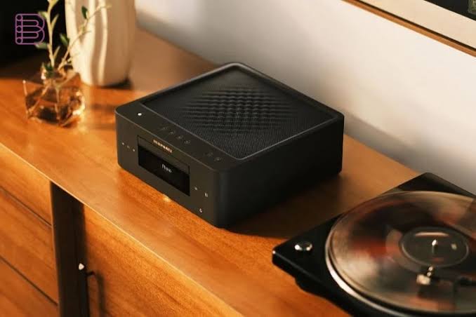 Marantz MCR 60n hi-fi system placed on a wooden shelf beside a vinyl record and plant, top view showing mesh ventilation grille