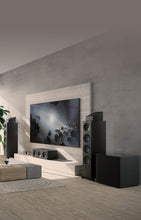 A modern living room featuring black KEF Q4 Meta speaker.