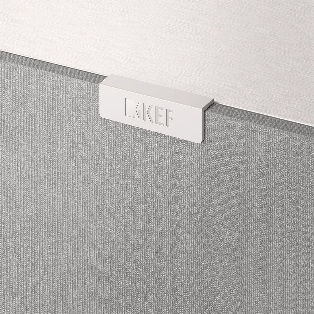 A closeup on a KEF Logo on a white KEF Q4 Meta On-Wall Speaker.
