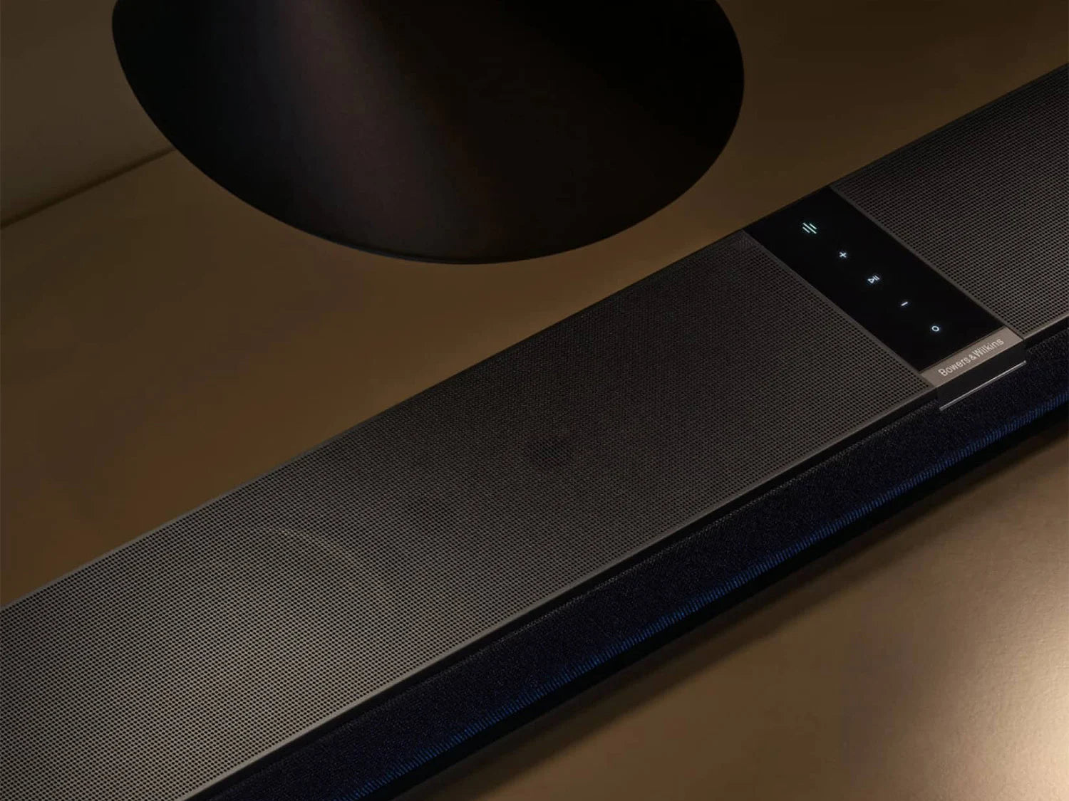 Close-up of a modern B&W Panorama 3 Sound Bar on a wooden surface with a dark background