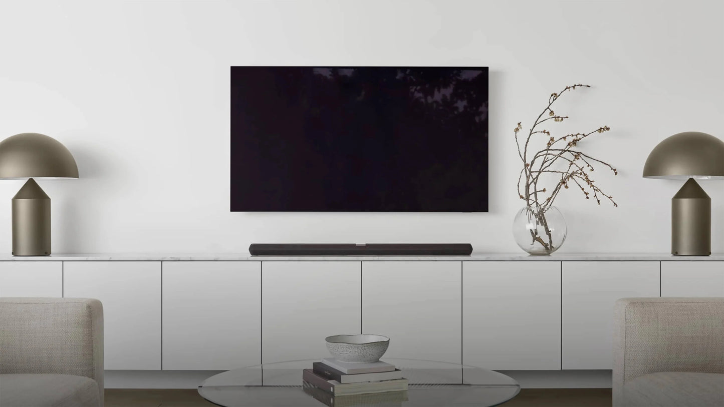 Modern living room with a television and B&W Panorama 3 Sound Bar setup on a white wall.