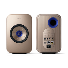 Two gold KEF speakers on a white background