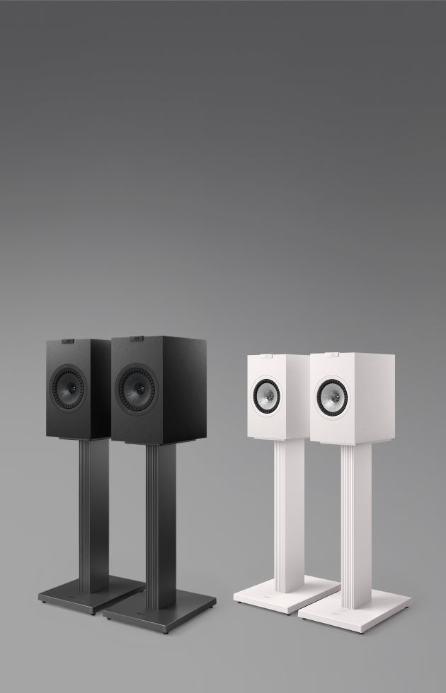 A pair of white and black KEF Q3 Meta Bookshelf Speakers on stands.