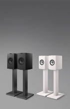A pair of white and black KEF Q3 Meta Bookshelf Speakers on stands.