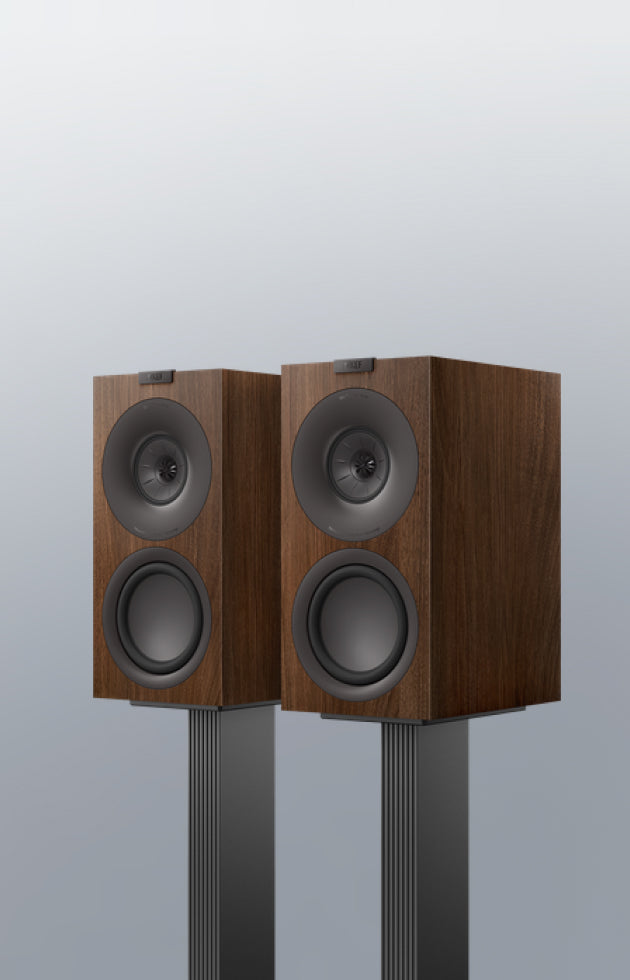 Pair of wooden speakers on KEF Dedicated Stand for Q Series against a light gray background
