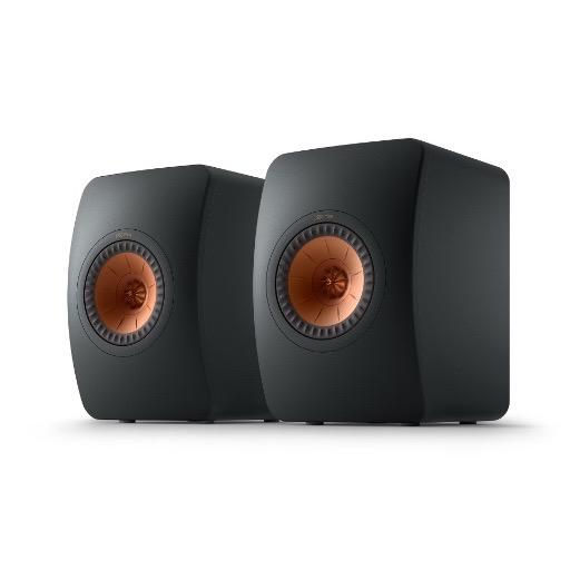A pair of KEF LS50META black bookshelf speakers with a visible copper dome tweeter.